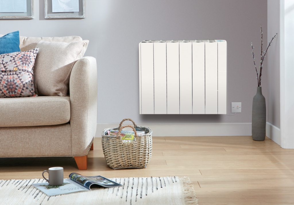 A white home radiator installed near the sofa in cold weather